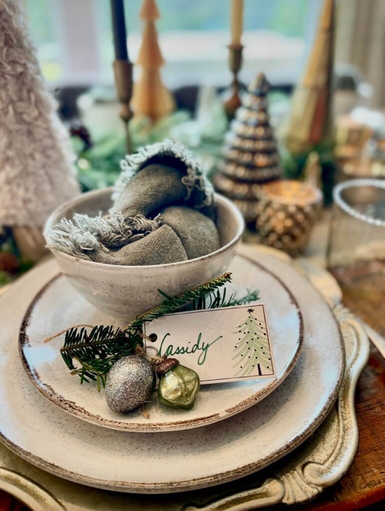 Holiday table place setting with personalized name card and festive accents on a Christmas table.
