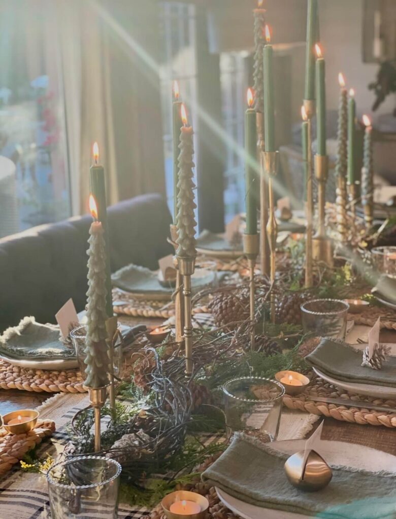 Cozy Christmas table with glowing candles creating an inviting holiday tablescape.