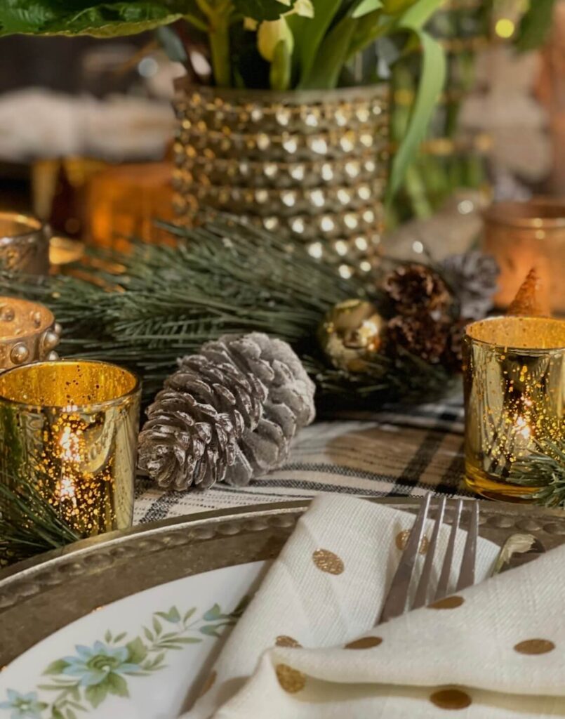 Detailed shot of layered textures on a Christmas tablescape including linen, plates, and decor.
