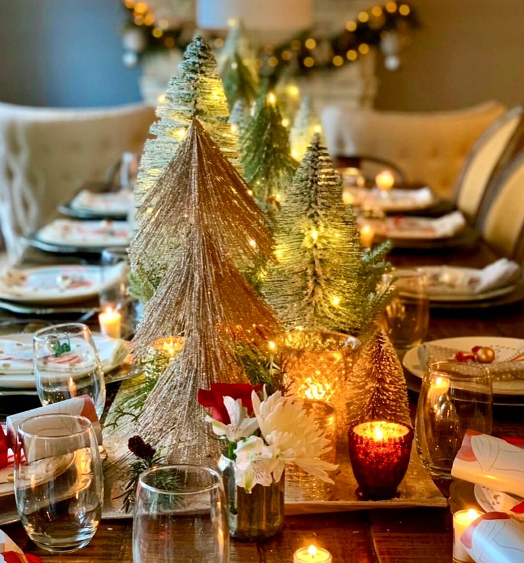 Beautiful Christmas table set with greenery and candles for a festive holiday table setting.