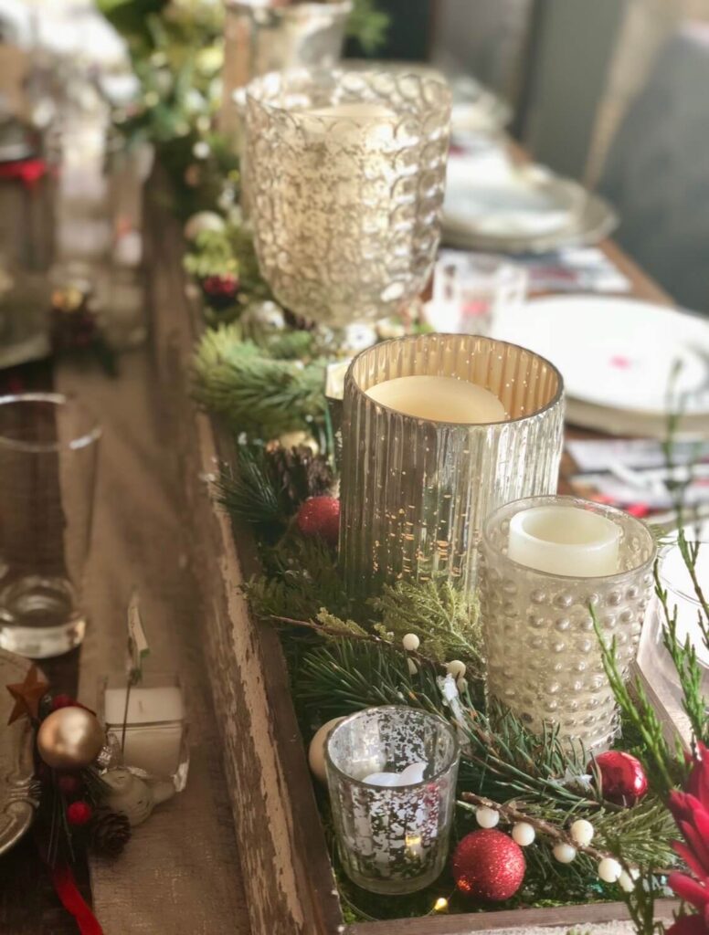 Eclectic mix of plates, glassware, and decorative elements on a Christmas table for a layered holiday table look